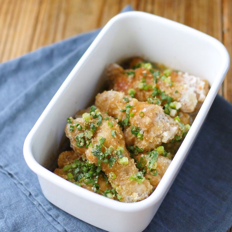 白い保存容器に入っている鶏手羽元唐揚げのねぎポン酢漬け