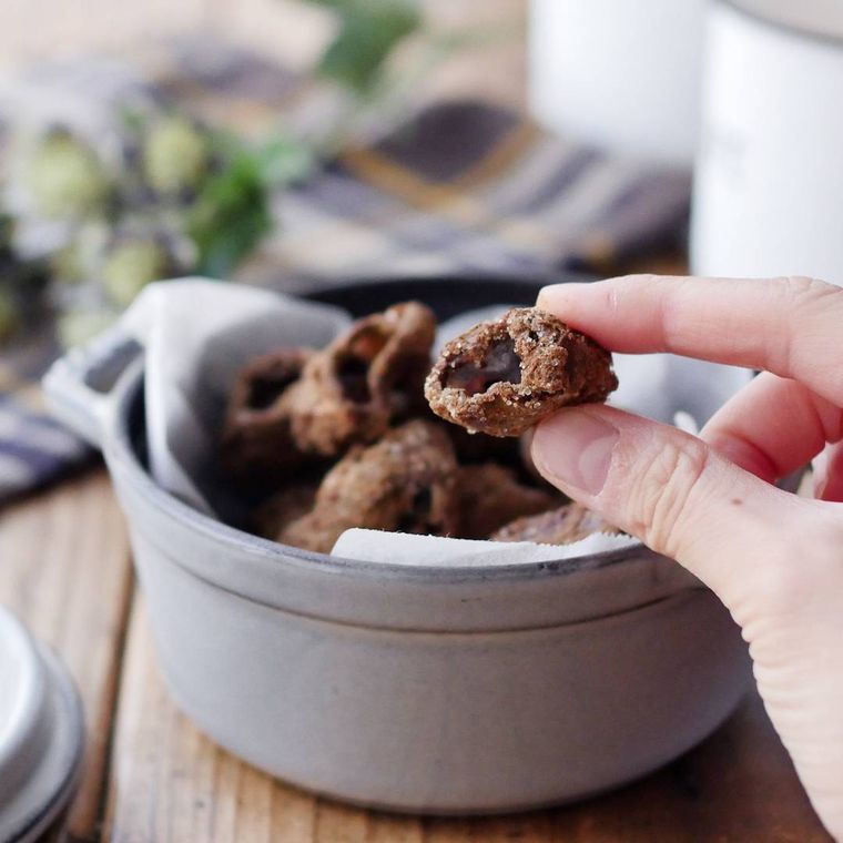 小鍋に盛りつけられたコブクチップを指でつまんでいる様子