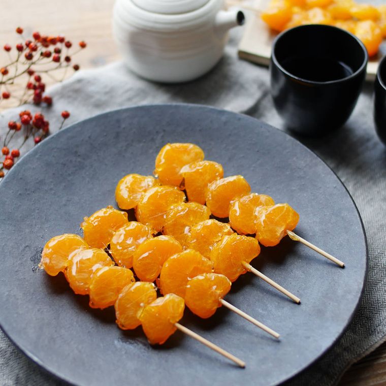 黒い皿に盛り付けられたみかんあめ