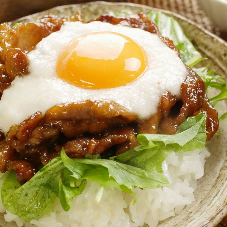 石目肌の皿に盛りつけられた卵黄トッピングの豚とろろ丼