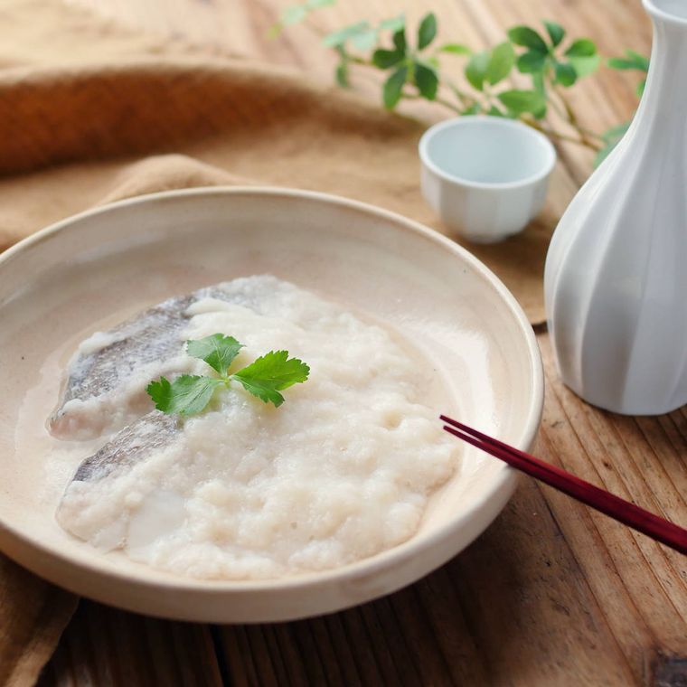 白い皿に盛りつけられたたらのとろろ蒸し、徳利とおちょこ