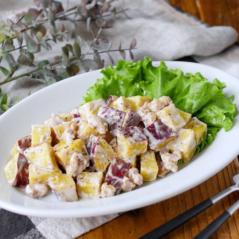 白い楕円の皿に盛り付けられたさつまいものヨーグルトサラダ