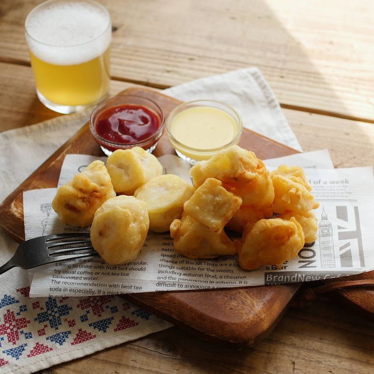 英字の紙を敷いた木製のボードに盛られたれんこんと里芋のチーズフリット