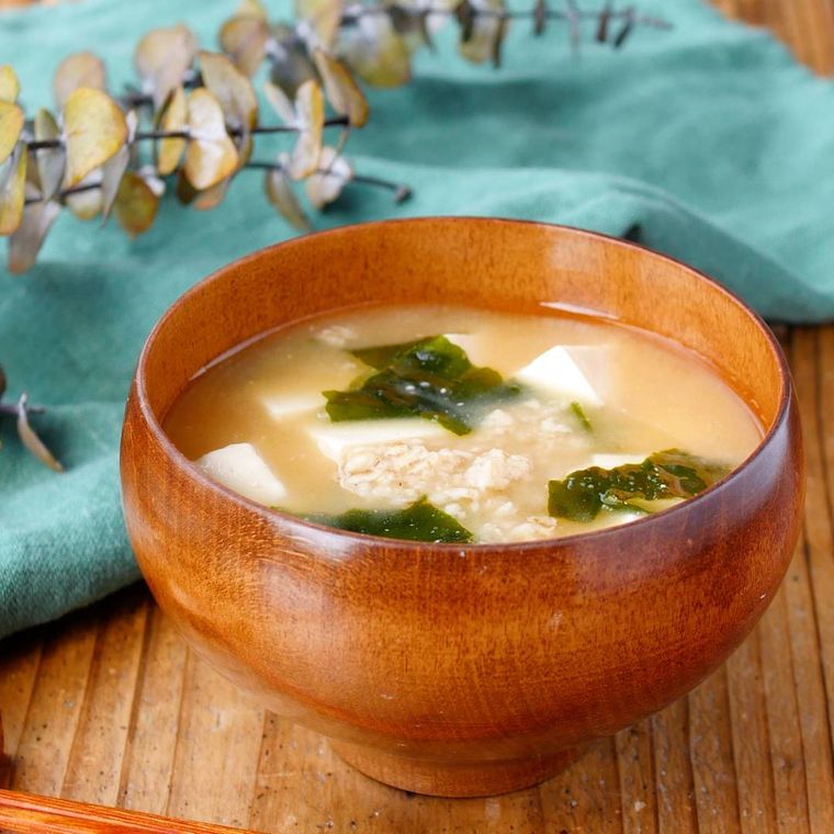 木のお椀に盛りつけられた豆腐とわかめのオートミールみそ汁