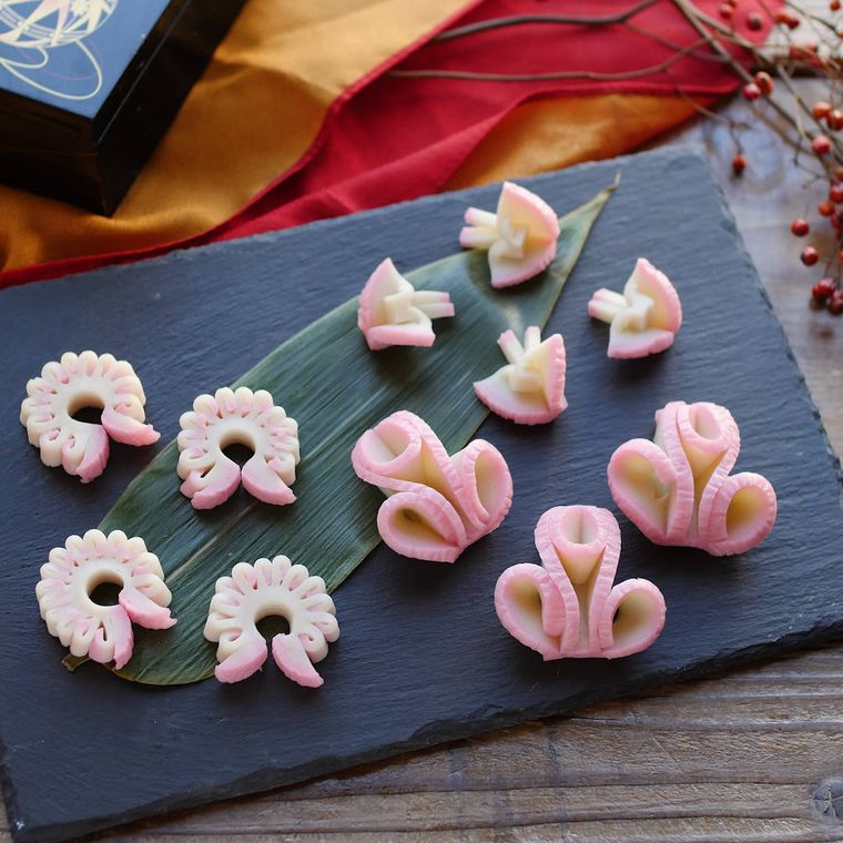 黒いプレートに盛り付けた飾り切りしたかまぼこ