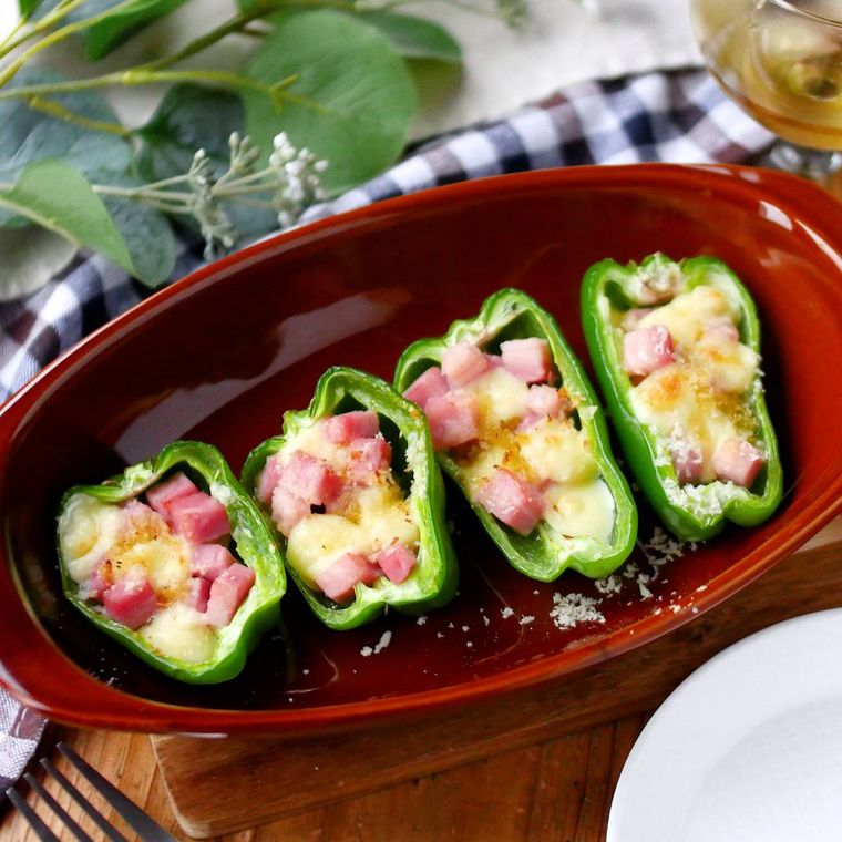 赤色のグラタン皿に入ったチーズとベーコンのピーマンカップ