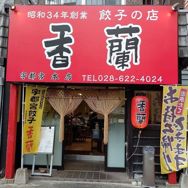 赤が目立つ餃子店「香蘭」の看板