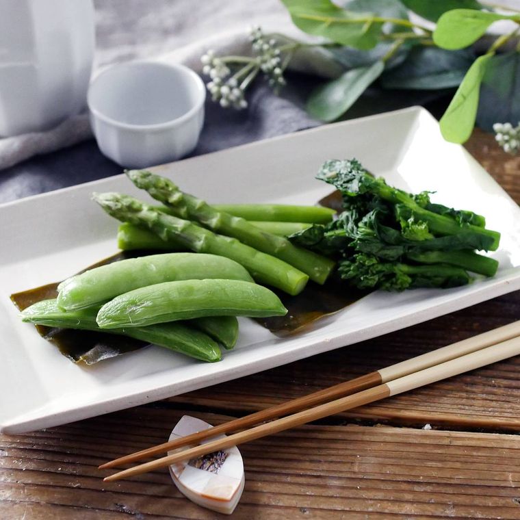 白い長皿に盛りつけられたアスパラガスや菜の花などの昆布締め
