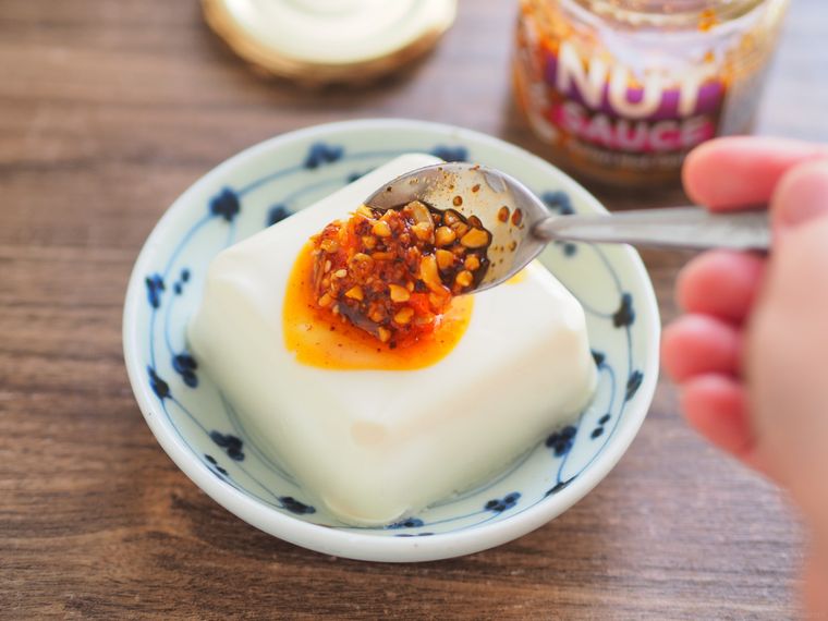 食べるナッツソースを豆腐にかける様子