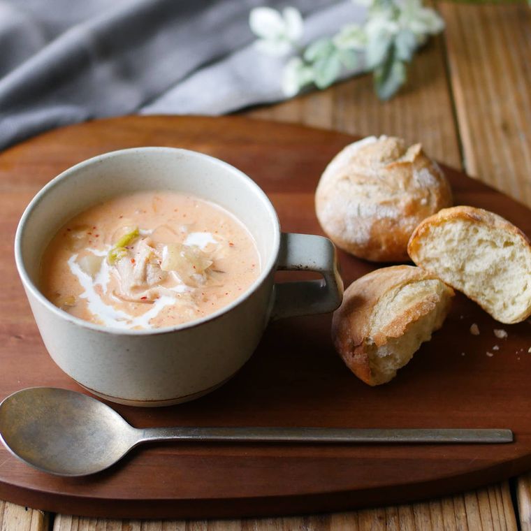 スープカップに盛られた豚肉と大根の豆乳キムチスープと、添えられたパン