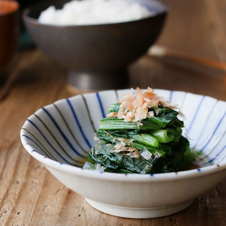 青色と茶色の縦縞が入った小皿に盛られた小松菜のおひたし