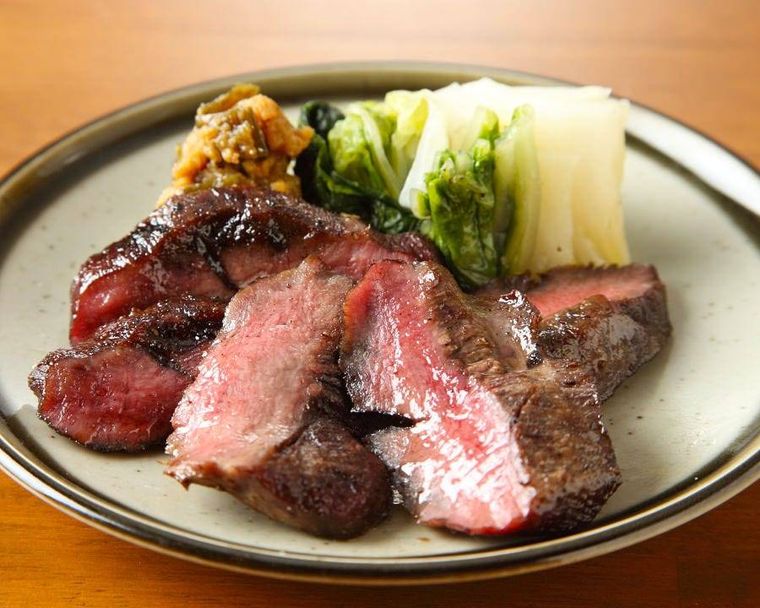 牛たんにお新香や唐辛子味噌が添えられている様子