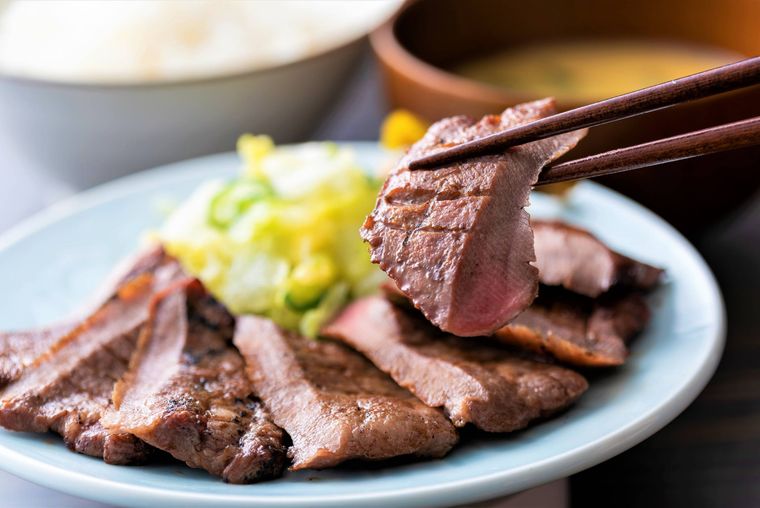 牛たんが箸で持ち上げられている様子