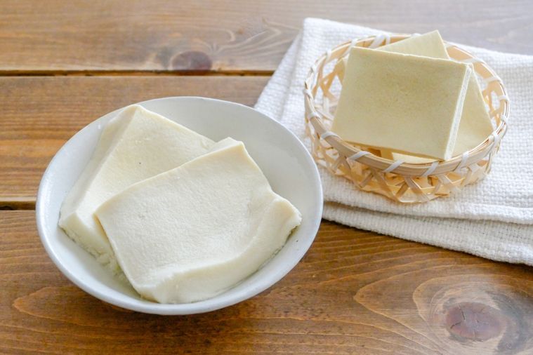 戻す前の高野豆腐と熱湯で戻した高野豆腐が並ぶ木製テーブル
