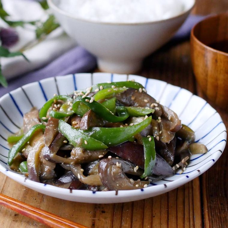 縦縞の入った白色の器に盛られたなすとピーマンのみそ炒め風