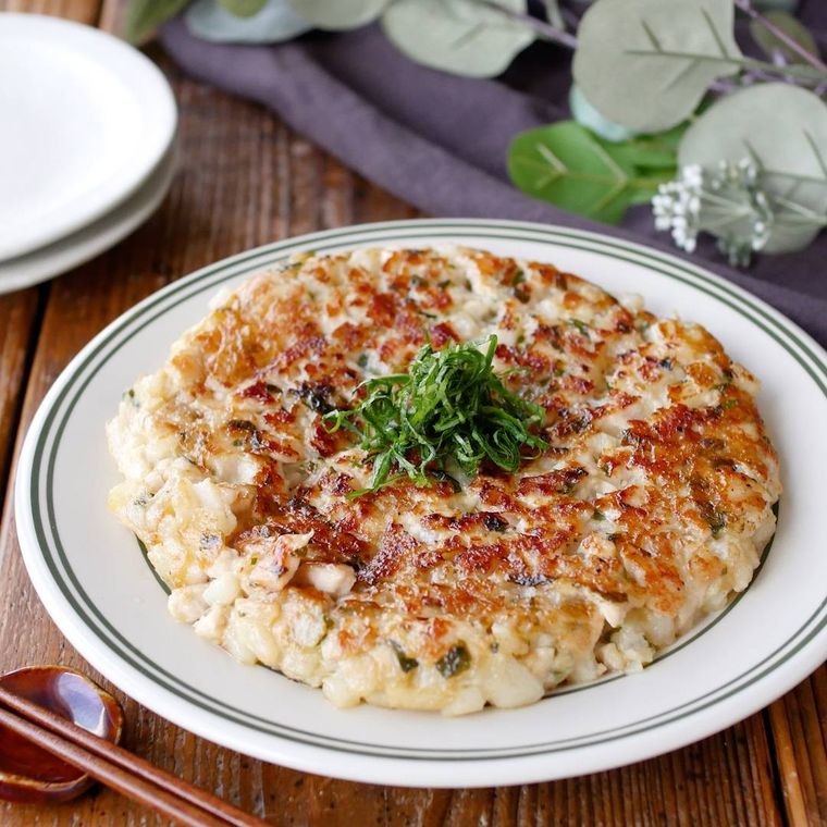 縁取りのある皿に盛りつけられた鶏肉と長芋の大葉入りつくね