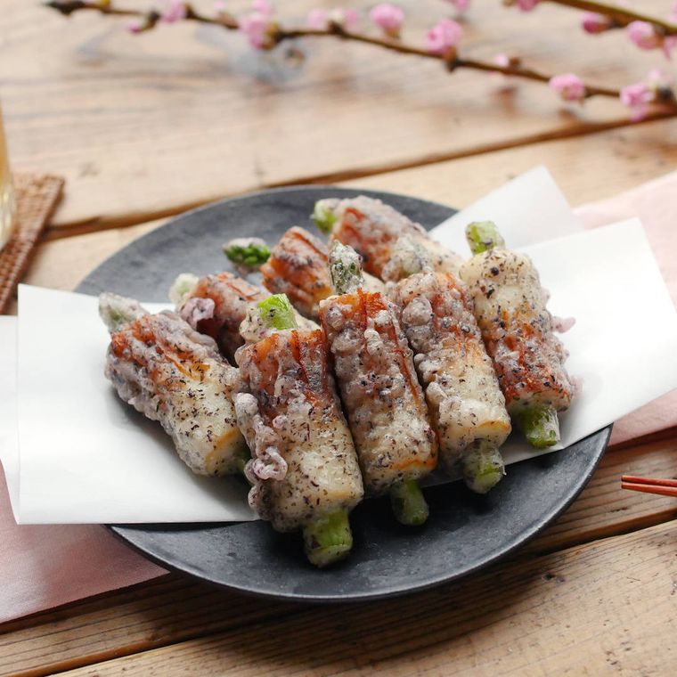 黒い皿に盛りつけられたアスパラちくわのゆかり揚げ