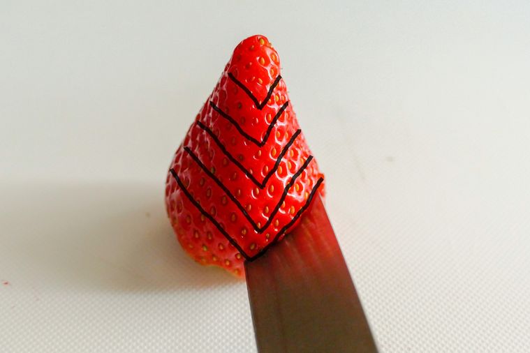 V字の線が5カ所入っているいちごに包丁を入れる様子