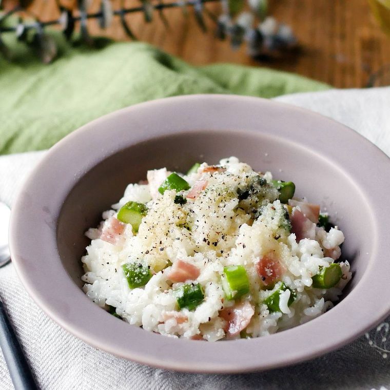 グレーの皿に盛られたアスパラガスとベーコンのチーズリゾット