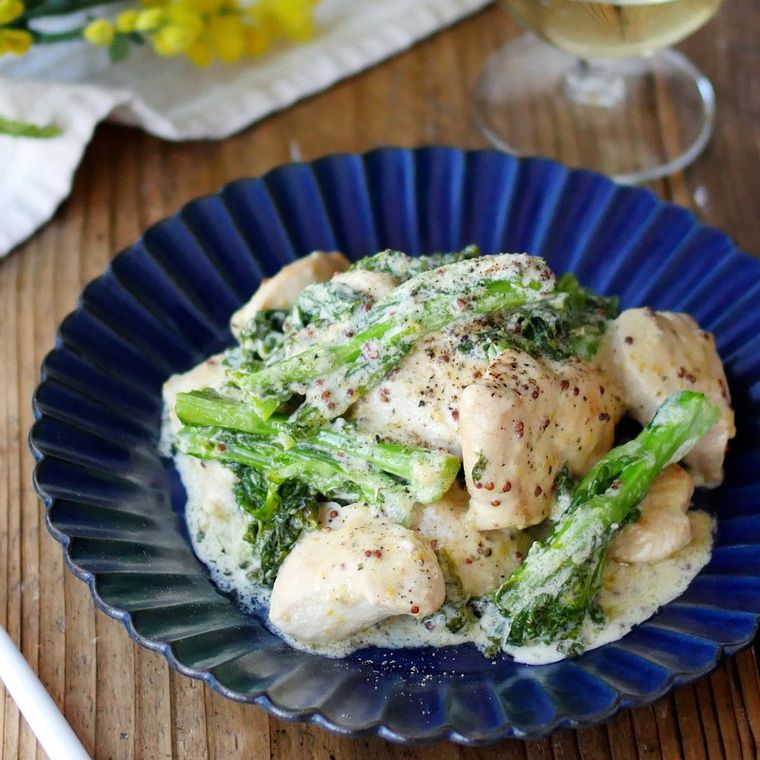 紺色の皿に盛られた鶏肉と菜の花のマスタードクリーム煮