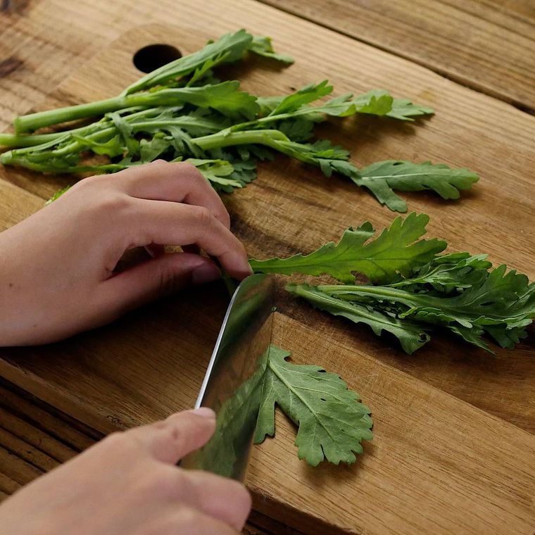 まな板の上で春菊を切っている