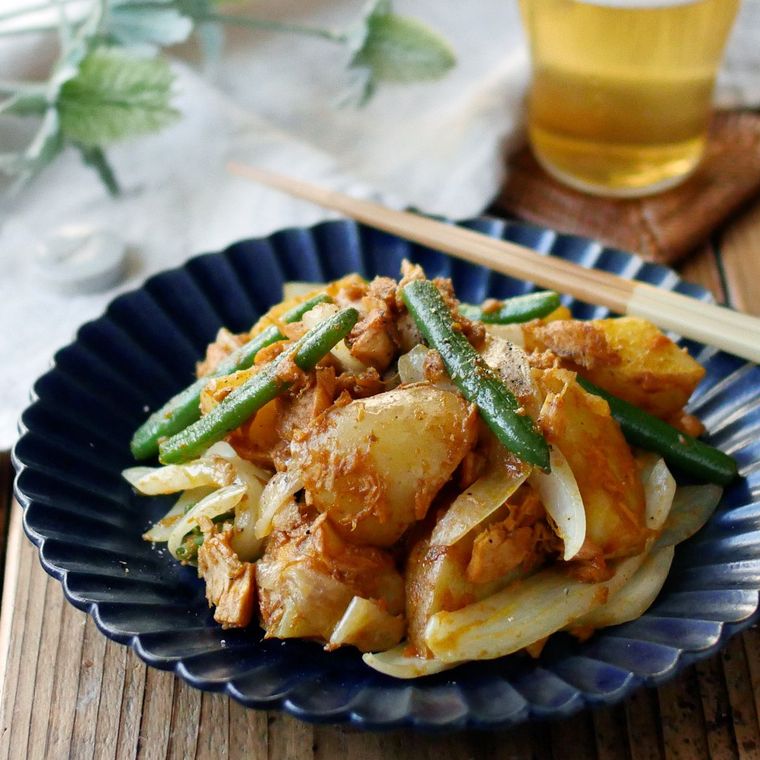 紺の皿に盛られた新じゃがと新玉ねぎのカレー炒め