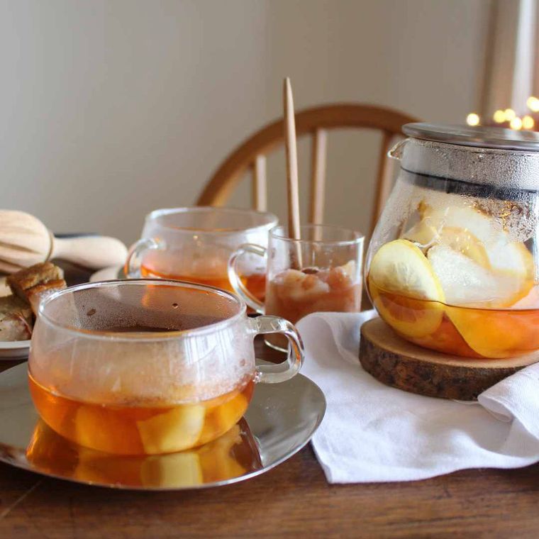 洋梨コンポートのごほうびティーが入ったティーポットとティーカップが置いてある