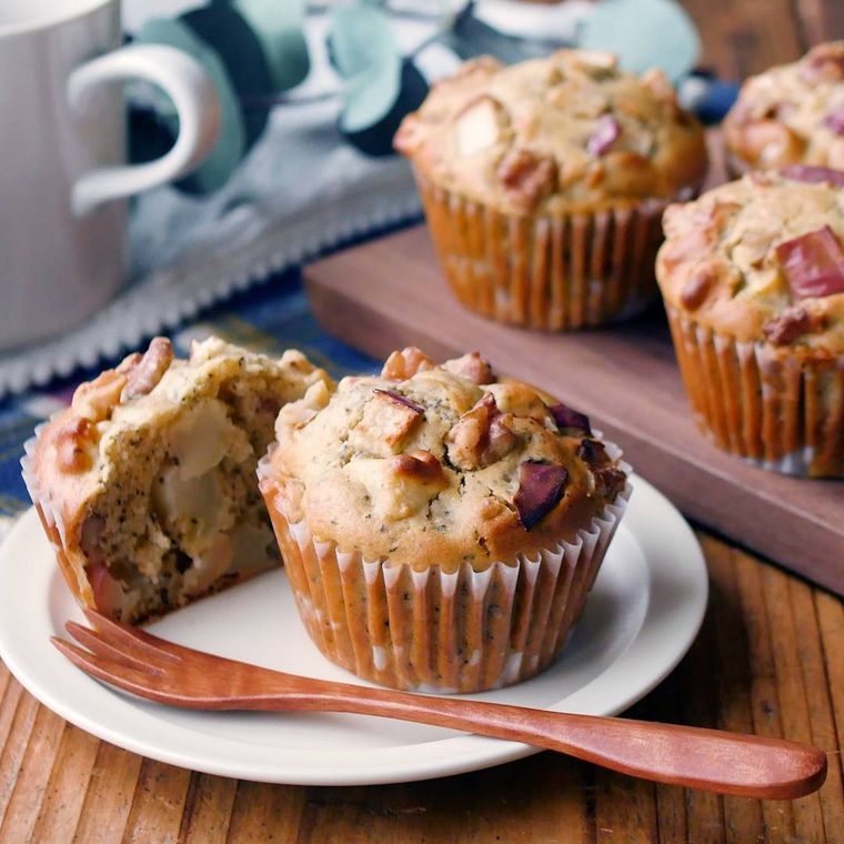 白色の皿にりんごとくるみの紅茶マフィンと木製フォークが置いてある様子