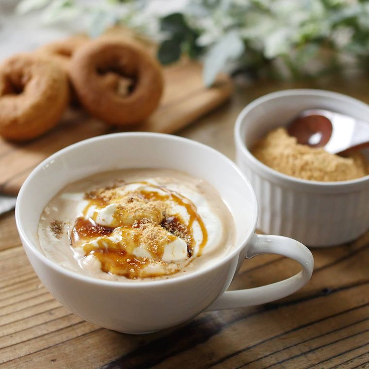 白色のティーカップに自家製きなこと黒蜜きなこチャイが入っていて左上にドーナツが置いてある様子