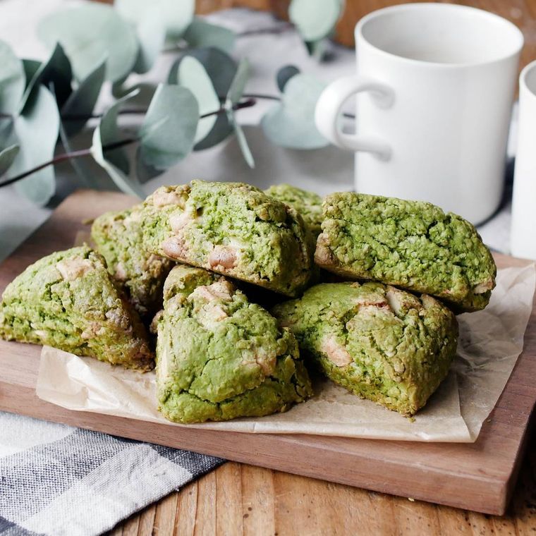 カッティングボードにのった抹茶とホワイトチョコのざくざくオートミールスコーン