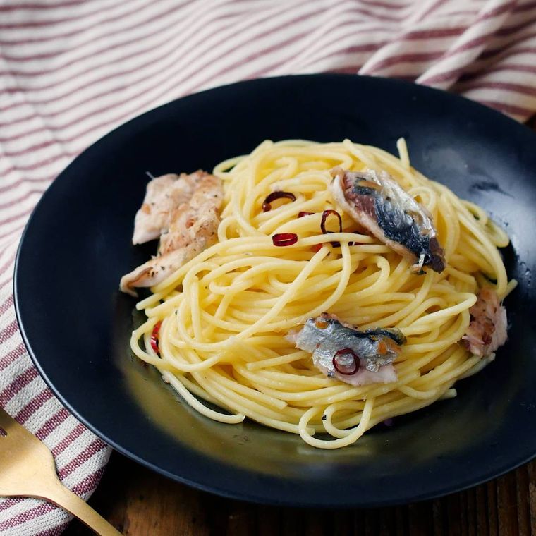 黒い皿に盛り付けたいわしのペペロンチーノ