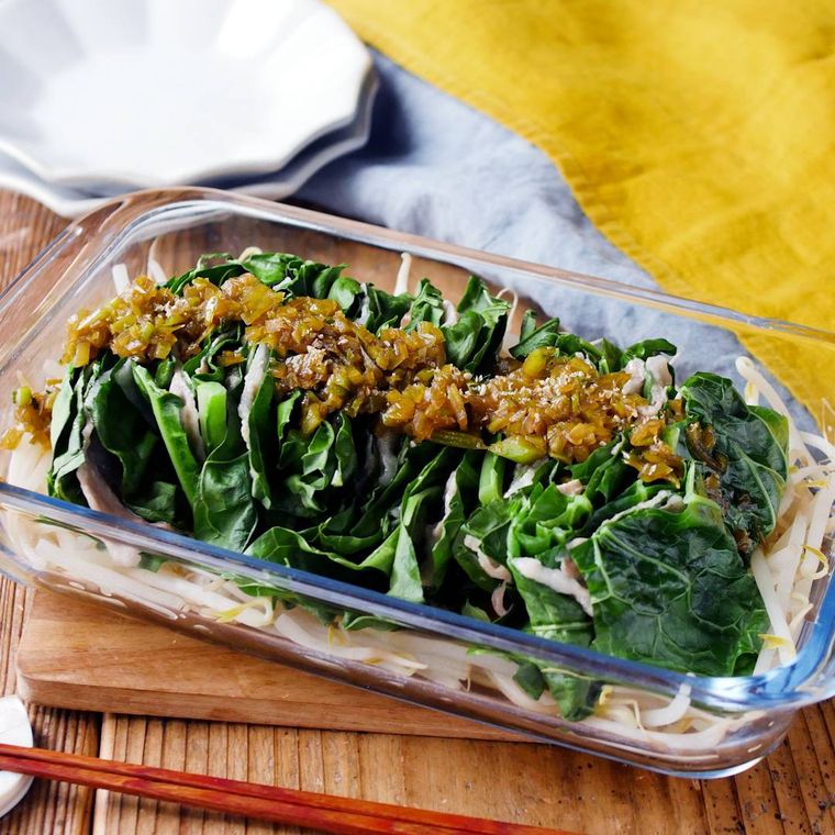 ガラス製の耐熱容器に入っているケールと豚肉のレンジ蒸し