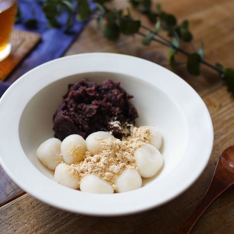 白い皿に入れた、小豆やきな粉を添えた甘酒白玉だんご