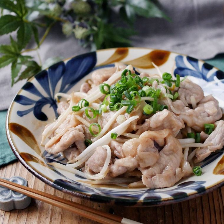 模様入りの皿に盛りつけられた豚肉ともやしのしょうが焼き