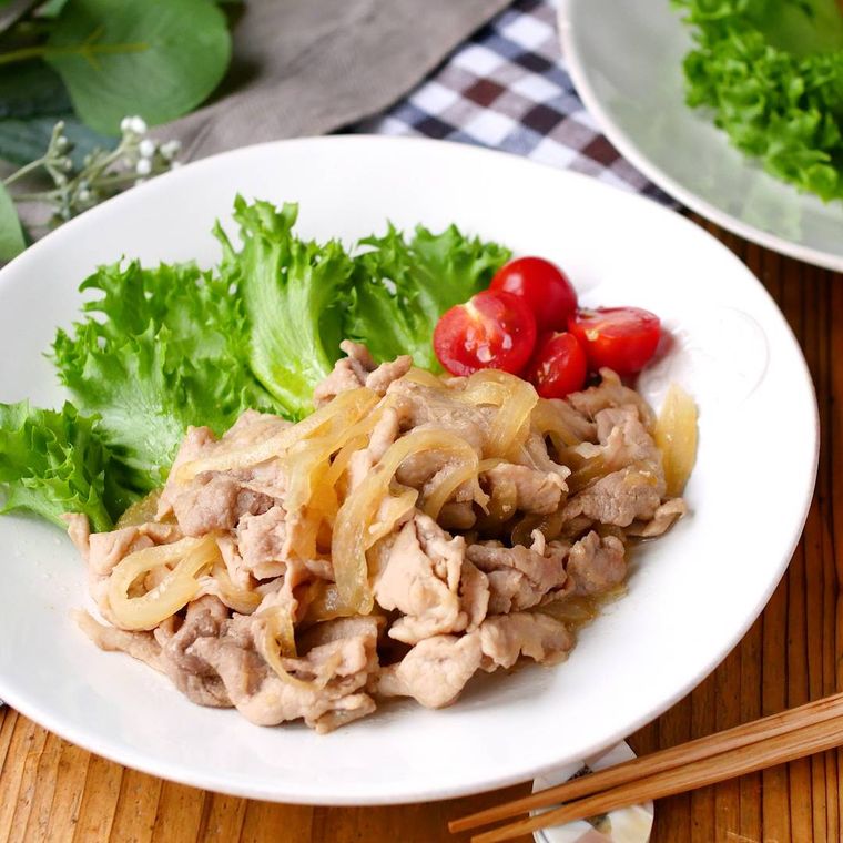 白い皿に盛りつけられた豚肉と玉ねぎのポン酢しょうが炒め