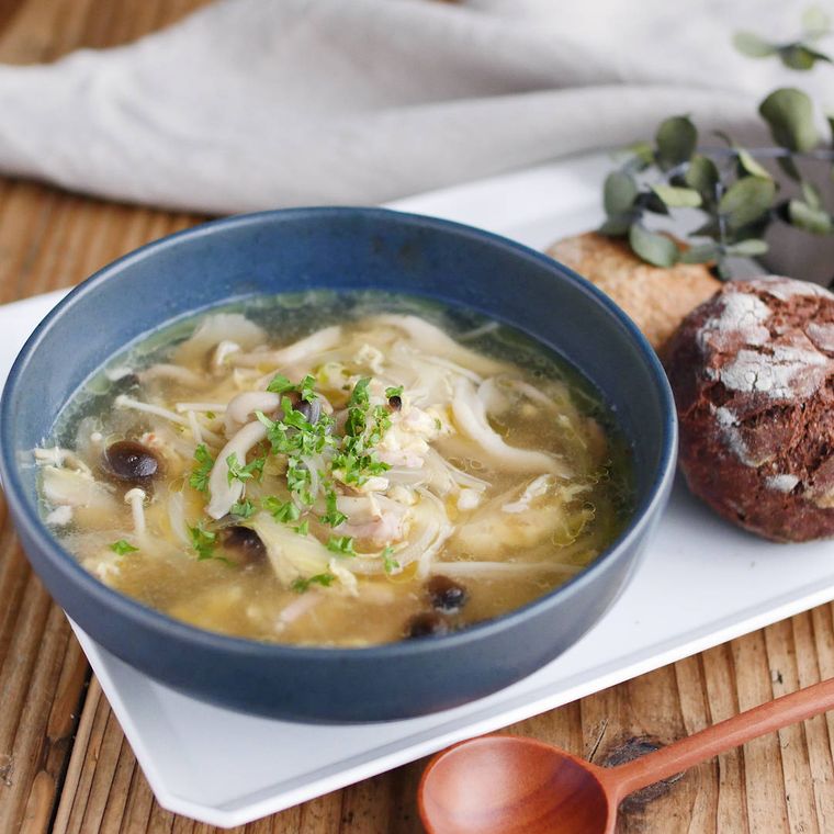 青い深皿に盛り付けられたきのことベーコンのガリバタスープ