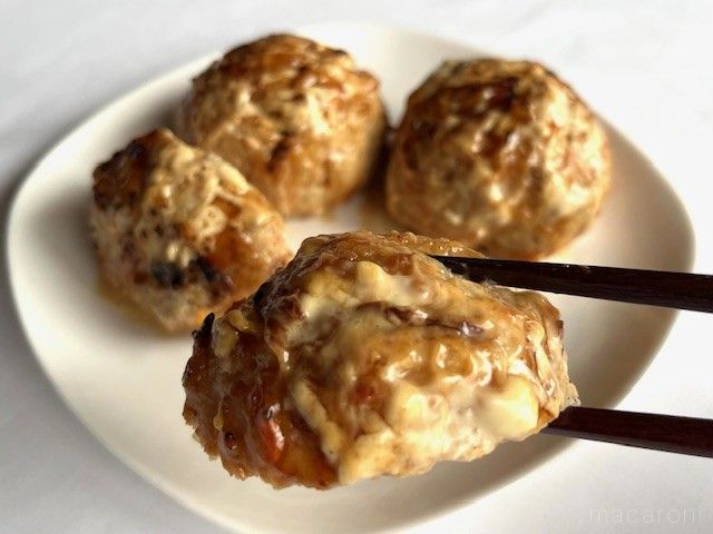 チーズが溶けたつくねを箸で持ち上げている