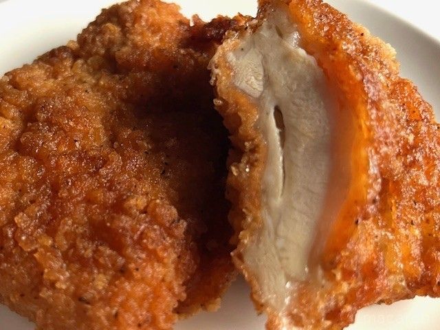 切り口からジューシーな肉汁があふれ出ているフライドチキン