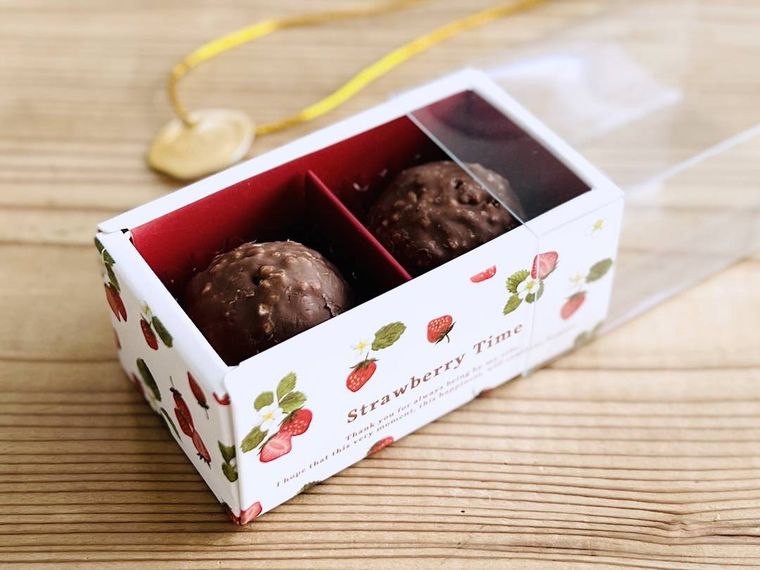 いちご柄のトリュフボックスにチョコレートを詰めた様子