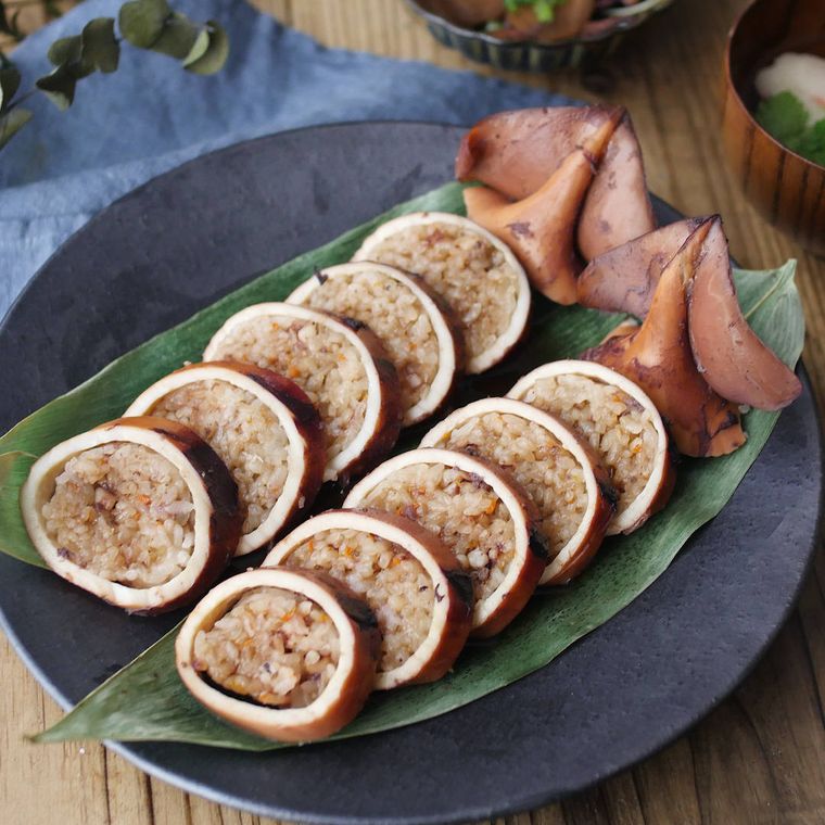 マットな黒色の皿に盛りつけられた切り餅入りのいかめし