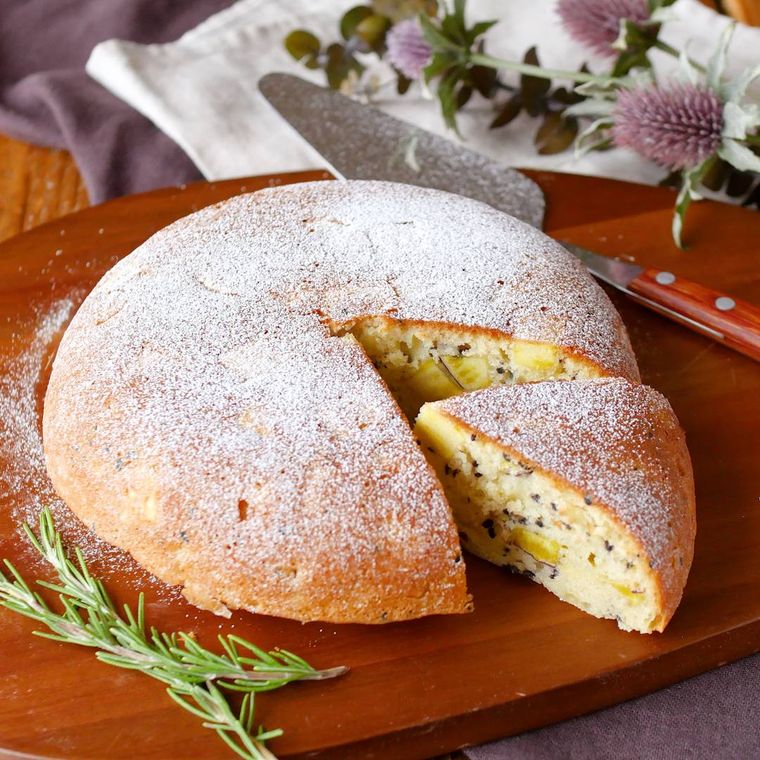 木製プレートに置いたホールのさつまいもケーキを切った様子