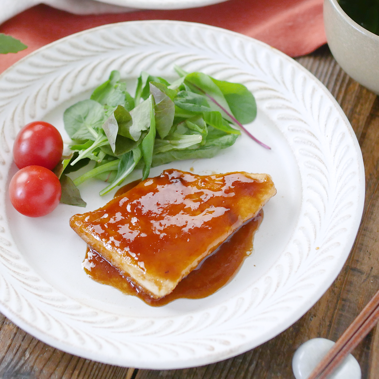 白色の丸皿に盛られためかじきのしょうが焼き