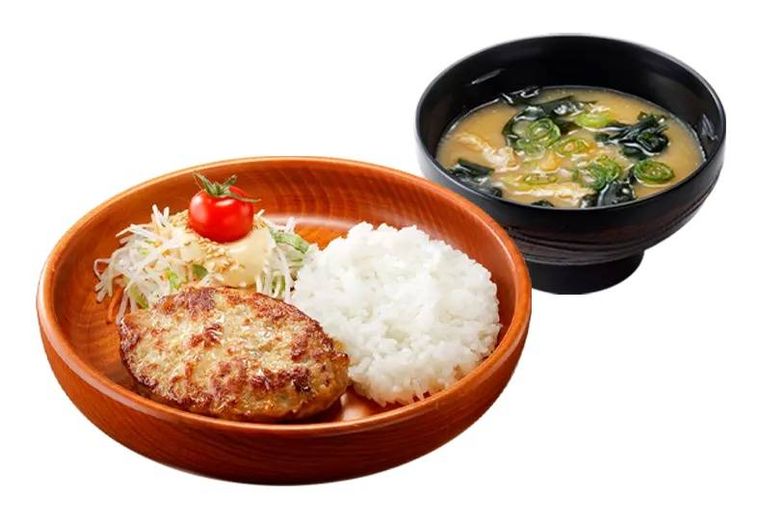 ハンバーグが入ったプレートと味噌汁が置かれている