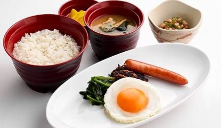 目玉焼き、ごはん、味噌汁、納豆などが置かれている