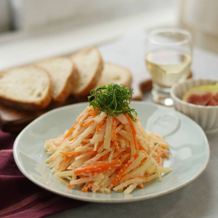 薄い青色の丸皿に盛られたじゃがいものタラモサラダ