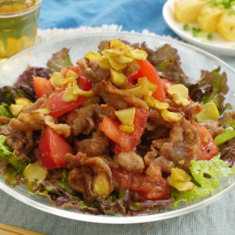 丸皿に盛り付けた豚こま肉とトマトのしょうがサラダ