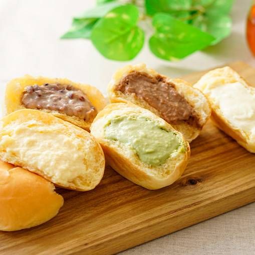 木のトレーに数種類のクリームパンが置かれている