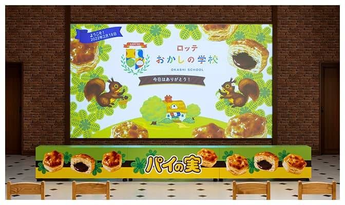 大型スクリーンにおかしの学校の映像が映し出されている