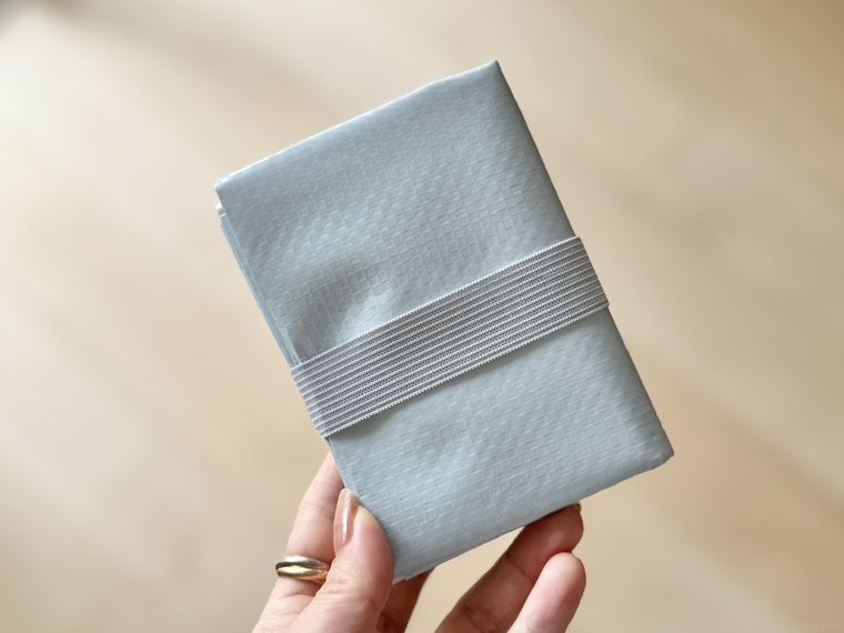 折りたたんだ状態のコンパクトレジャーシートを持っている様子