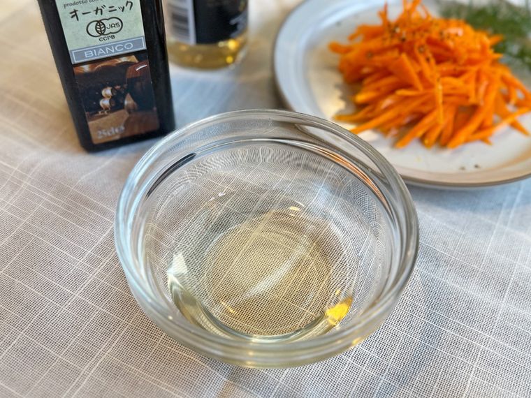 透明な器に入ったワインビネガーと、バルサミコ酢、グレーのお皿にのったキャロットラペ